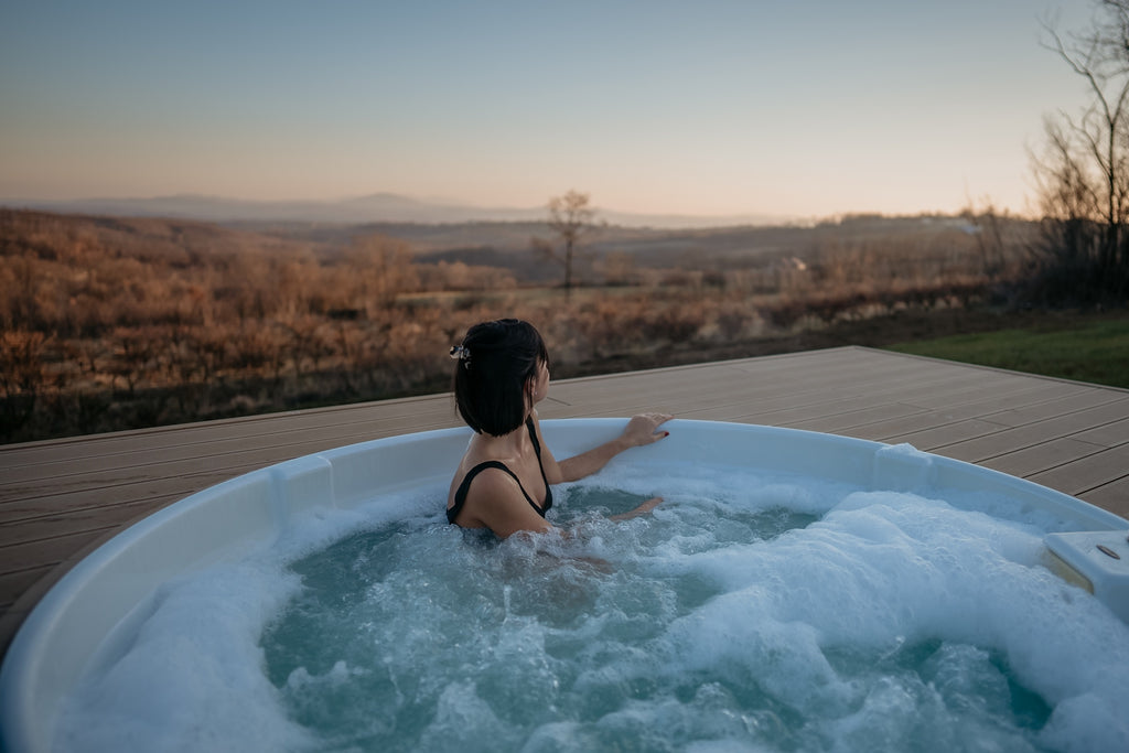 Woman looking at the horizon while enjoying a hot tub outdoors